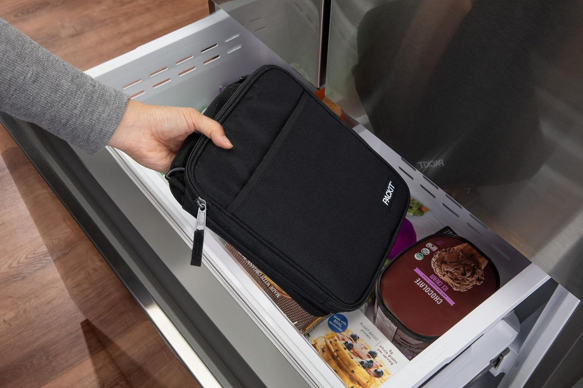 PackIt® - Fiambrera cruzada congelable, negra, construida con tecnología ECOFREEZE®, totalmente congelable, plegable, reutilizable, con asa superior, bolsillo frontal deslizante. Llevar sin esfuerzo